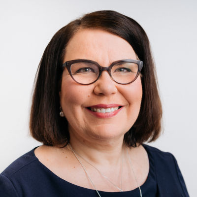 Merja Ylä-Anttila. Tummahiuksinen, silmälasipäinen nainen