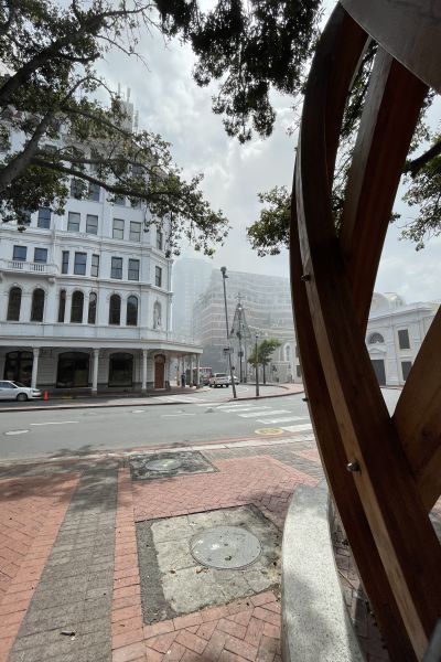 Rök stiger i Kapstaden ovanom byggnader. Bilar kör på gatorna.