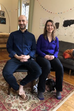 Annie Tummino, Meir Hamilton och Enzo. Annie Tummino och Meir Hamilton i vardagsrummet. Sonen Enzo tittar fram under stolen.