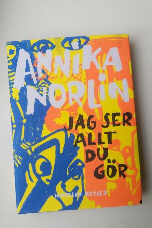 Bild på pärmen av Annika Norlins novellsamling "Jag ser allt du gör" som går i orange, blått och gult.