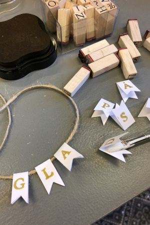 Gör en vimpel med tryckt text på pappersbitar klippta pappersvimplar med tryckta bokstäver