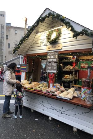 All julhandel sker inte i köpcentren. Hantverksmarknaderna dyker upp också i New York Mor och dotter köper popcorn vid julmarknad i Brooklyn.