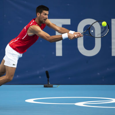 Novak Djokovic slår en boll i OS.