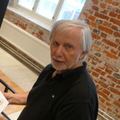 Kalevi Laalo pitää kädessään piirtämäänsä pilapiirrosta Puuvillan Kansantorilla.