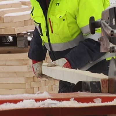 Mies sirkkelöi lautaa rakennustyömaalla.