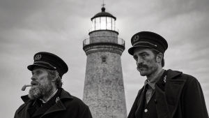 Konflikter är under uppsegling då Thomas Wake (Willem Dafoe) och Ephraim Winslow (Robert Pattison) då ska leva på samma ö. En svartvit bild på Thomas Wake (Willem Dafoe) och Ephraim Winslow (Robert Pattison) står nedanför en fyr och tittar ut mot havet.