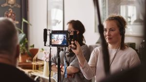 Anna Blom under inspelningen av kortfilmerna. Anna Blom håller i en monitor under inspelningen av Längtan-kortfilmerna.