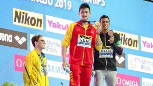 Mack Horton protesterar under medaljceremonin. Mack Horton står bakom podiet, när Sun Yang och Gabriele Detti poserar med sina medaljer.