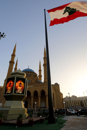 En jättelik libanesisk flagga vajar framför en Ramadan-lampa utanför Al Ameenmoskén i Beirut En jättelik libanesisk flagga vajar framför en Ramadan-lampa utanför Al Ameenmoskén i Beirut