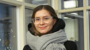 Catharina Baumgartner. En ung kvinna med ljusbrunt hår och glasögon står framför ett fönster.