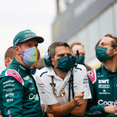 Sebastian Vettel tallihenkilökunnan edessä maski naamallaan.