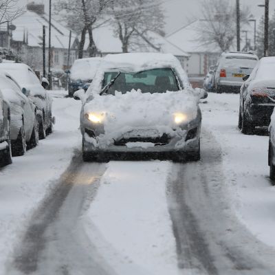 Bil som är täckt av snö i London. 