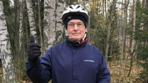 Antti ei tunnustaudu himopyöräilijäksi, vaikka matkoja kertyi kaupunkipyörällä tällä kaudella 700. Antti Oramo seisoo peukalo pystyssä, taustalla syksyinen metsä.