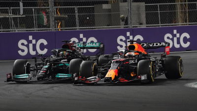 Lewis Hamilton och Max Verstappen kör i en kurva jämsides.