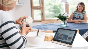 Netistä löytyvät helposti vaikka ruokareseptit. Nainen leipoo eli kaataa jauhoja kulhoon katsoen reseptiä tablettitietokoneelta.