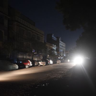 Bara billyktor lyste upp ett bostadområde i hamnstaden Karachi sent på lördag kväll. 