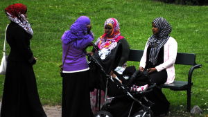 Unga med somalisk bakgrund vill gärna idka hobbyverksamhet på svenska. Två somaliska kvinnor sitter på en bänk. Två somaliska kvinnor står framför dem. En av dem har en barnvagn.