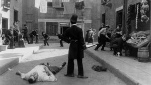Charles Chaplin: Hiljainen katu. Charles Chaplin (selin) elokuvassa Hiljainen katu (Easy Street, 1917)