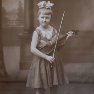 Tuleva operettitähti Hilkka Kinnunen rusettipäisenä pikkutyttönä viulu ja jousi käsissään valokuvassa vuodelta 1931.