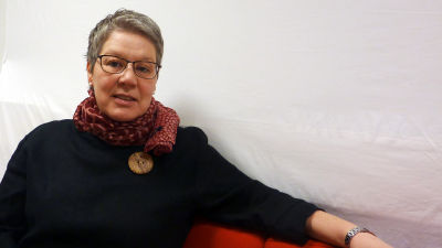 Camilla Grundström sitter i en soffa.
