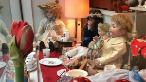 Ritva Blomqvist har prytt julfönstret med porslinsdockor och röda amaryllisar. Porslinsdockor och röda amaryllisar pryder ett julfönster.
