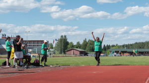 Pirjo Saukkonen tuulettaa voittoheittoaan. nainen nostaa kätensä ilmaan heittonsa jälkeen urheilukentällä.