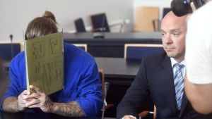 Häktningsförhandlingarna tolkades till svenska. På bilden syns den äldre brodern och hans advokat. Arkivbild. Den äldre brodern täckte också sitt ansikte.