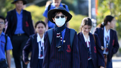 Skolelever på väg till sin skola i Brisbane, Queensland på måndagen 11.5, deras första dag i skolan på flera veckor.