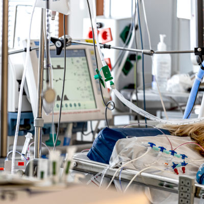 En patient ligger i en sjukhussäng, slangar leder till monitorer på intensivvårdsavdelningen för coronapatienter.