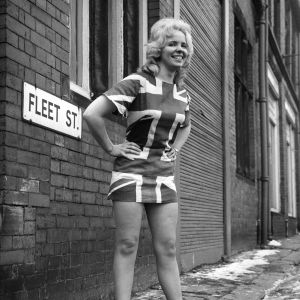 Minikjolen skapades av designern Mary Quant på 1960-talet. En kvinna poserar i en minikjol med Englandsflagga 1960-tal.