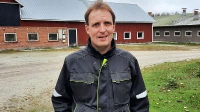 En man som står framför ett fähus.