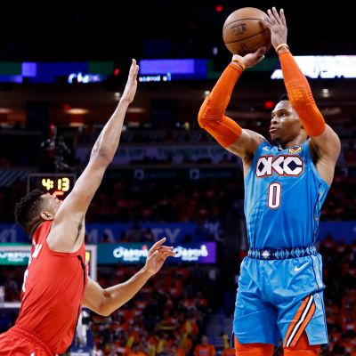 Portland Trail Blazers player CJ McCollum (L) tries to block a shot against Oklahoma City Thunder player Russell Westbrook