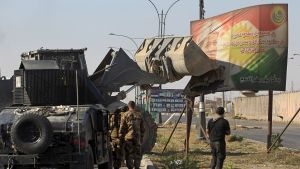 Irakiska styrkor använde en traktor för att ta ner ett plakat med Kurdistans president Massoud Barzani. Bilden togs på måndagen i utkanterna av Kirkuk. Irakiska styrkor använde en traktor för att ta ner ett plakat med Kurdistans president Massoud Barzani. Bilden togs på måndagen i utkanterna av Kirkuk.