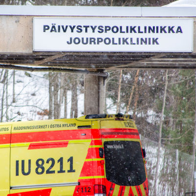 En ambulans står framför Borgå sjukhus. På sjukhuset står det "jourpoliklinik".