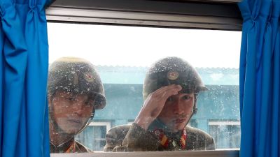 Nordkoreanska soldater kikar genom ett fönster i gränsstaden Panmumjom, som ligger på den Sydkoreanska sidan.