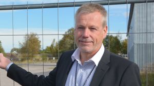 Ralf Lindén har inte upplevt att algerna skulle påverka marknaden negativt. En man i randig skjort aoch kostym utomhus i solen vid stängsel.