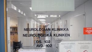 Det är en muterad gen på X-kromosomen, som är en av de könsbestämmande kromosomerna, som orsakar Kennedys sjukdom. Dörren till den neurologiska kliniken i ett sjukhus