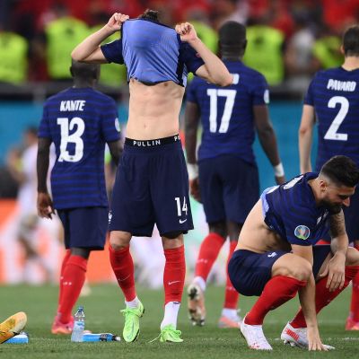 Franska fotbollspelare deppar efter matchen, Spelare med nummer 14 drar tröjan över huvudet.