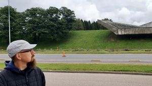 Oliver Orro står framför monumentet i Maarjamäe. Oliver Orro står framför Maarjamäe minnesmärke och tittar upp mot det.