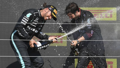 Lewis Hamilton spruzza champagne in passerella.