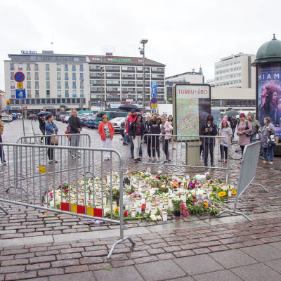 Människor placerar blommor och ljus på Salutorget i Åbo på lördagen den 19 augusti 2017.