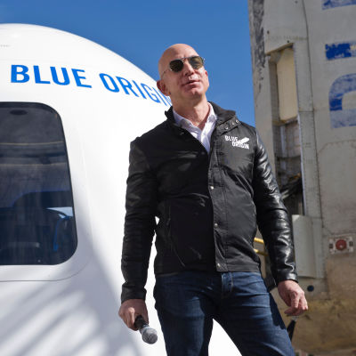 Jeff Bezos med solglasögon framför Blue Origins rymdkapsel 2017.