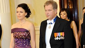 Republikens president Sauli Niinistö med fru Jenni Haukio välkomnar gästerna på torsdag förmiddag. Kvinna och man går längs med röd matta