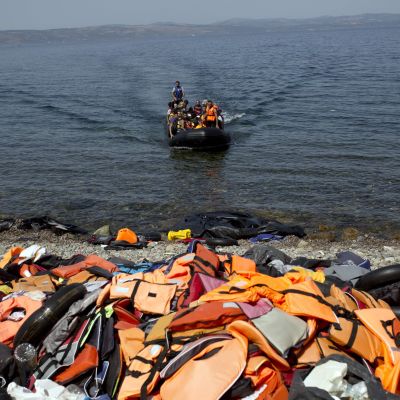 Gummibåt med asylsökande och migranter anländer till Lesbos, till en strand täckt av flytvästar 10.9.2015