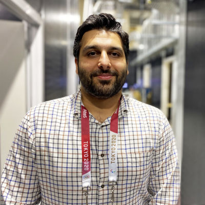 Ali Al-Naama ser in i kameran. Han är iklädd rutig skjorta.