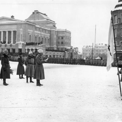 Miehet seisovat torilla sodan alkamisen muistokatselmuksessa.