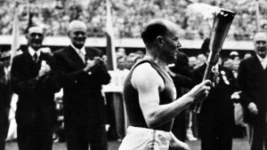 Paavo Nurmi löper in i stadionborgen i OS-invigningen 1952 i Helsingfors. Paavo Nurmi med OS-elden 1952.