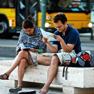 Turistit tutkivat sanakirjaa ja karttaa