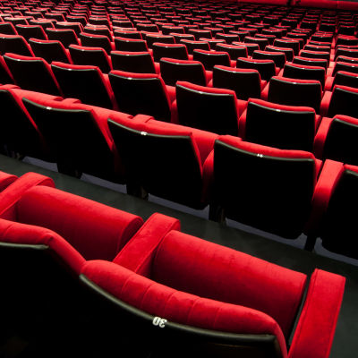 Röda stolar i en teater- eller biosalong.