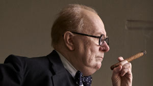 Många timmar i sminket och en mängd kroppsproteser gör Gary Oldman till Winston Churchill. Närbild på Winston Churchill (Gary Oldman) i profil med cigarr i handen.